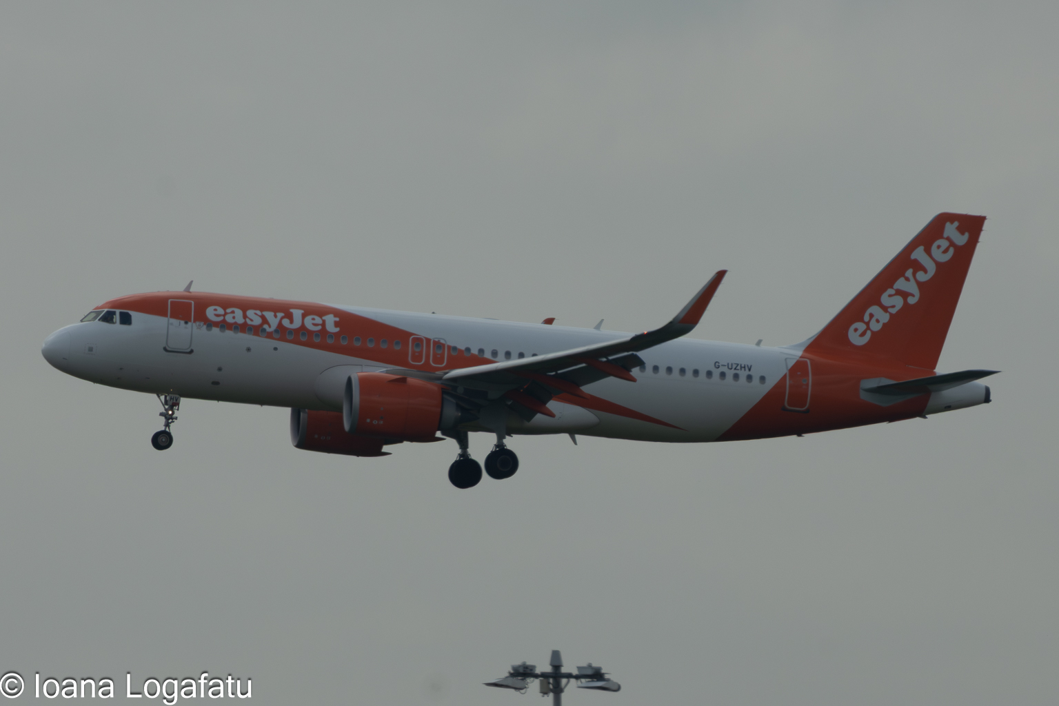 Airliner gliding through overcast skies above city